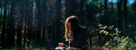 A woman reading in the woods