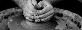 Hands shaping a bowl on a potter's wheel